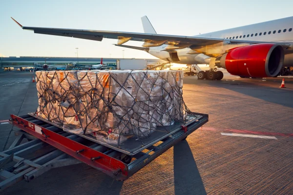 Air freight cargo ready for loading beside an aircraft